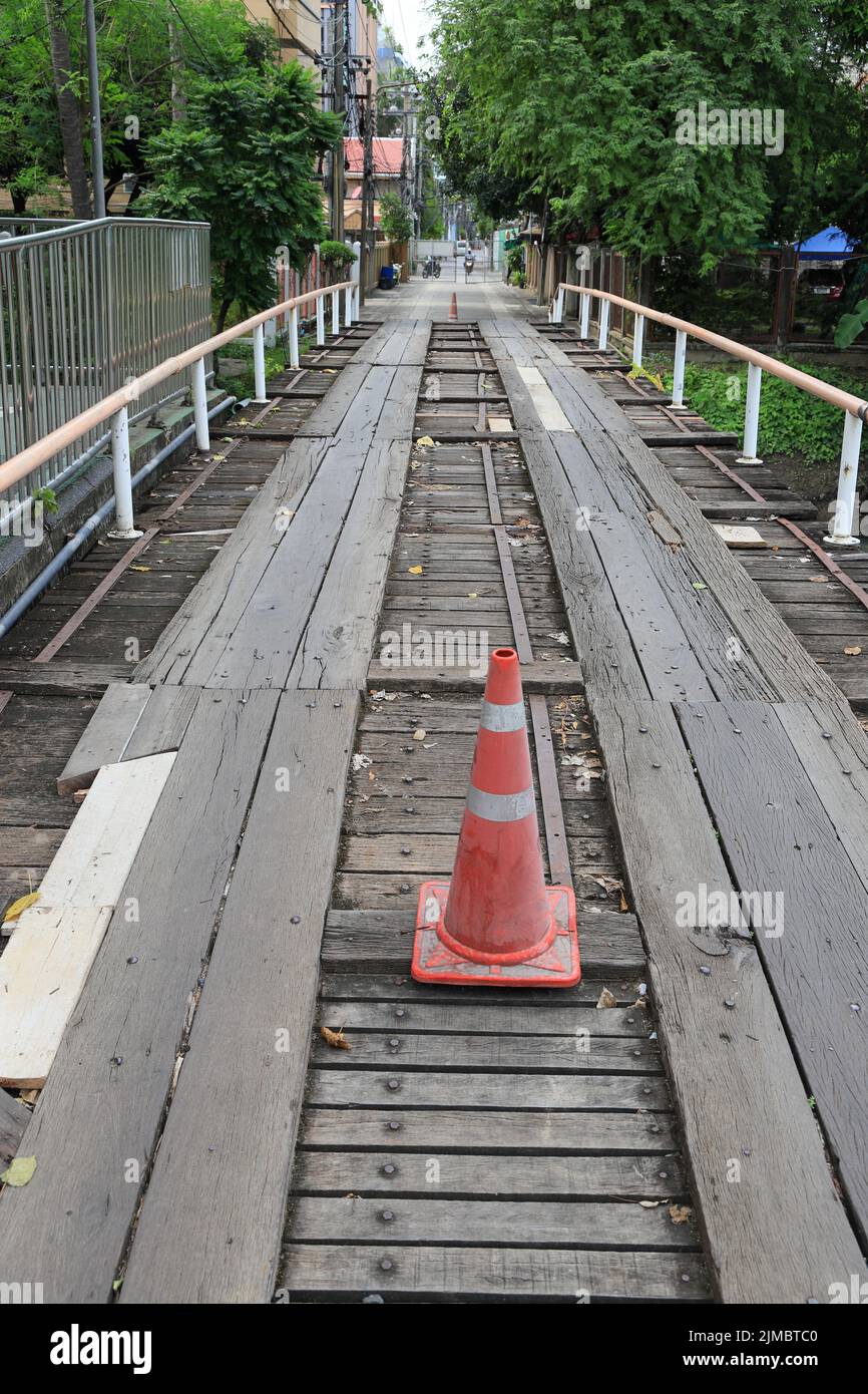 Old broken down wooden bridge with traffic cone for Warning not to use. Stock Photo