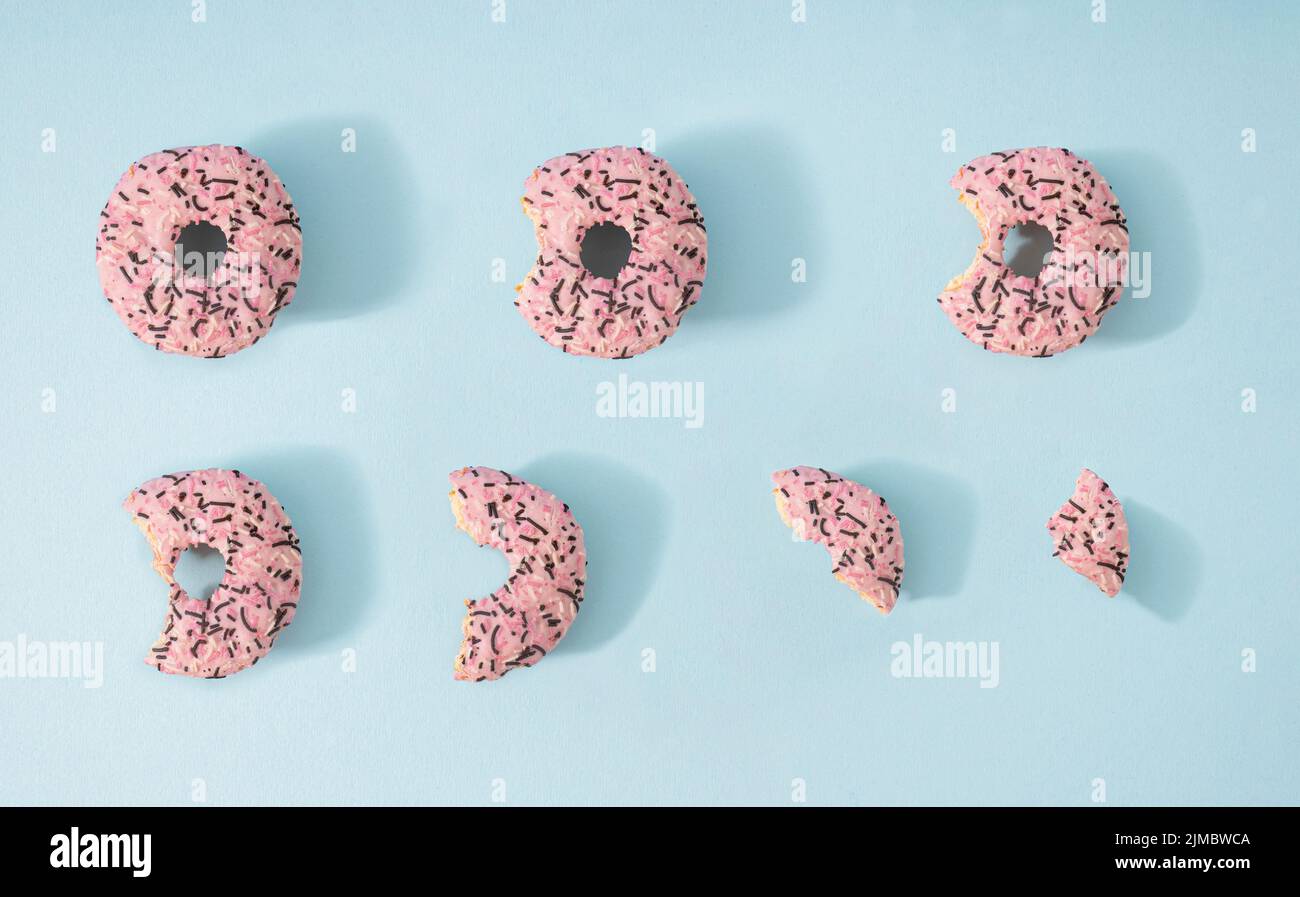 Creative flat lay concept on pastel blue background of a sweet delicious donuts. Stock Photo