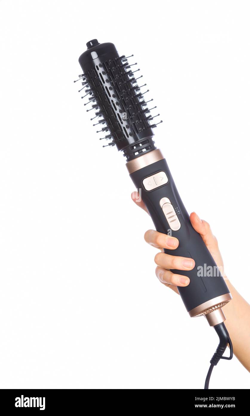Hand holding hair curling iron round brush Stock Photo Alamy