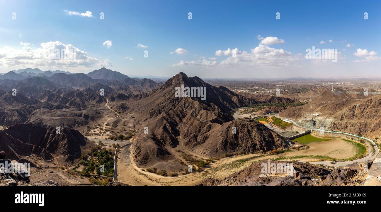 Wadi Shawka Dam panorama, with empty dam, dry riverbed and rocky Hajar Mountains, United Arab Emirates. Stock Photo