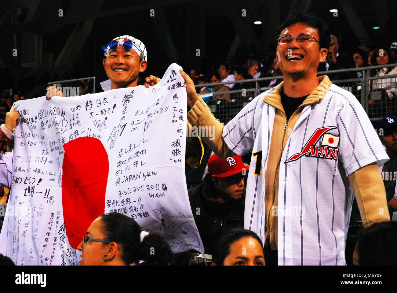Fans of the Japanese National baseball team proudly wave the flag of Japan at an international game Stock Photo