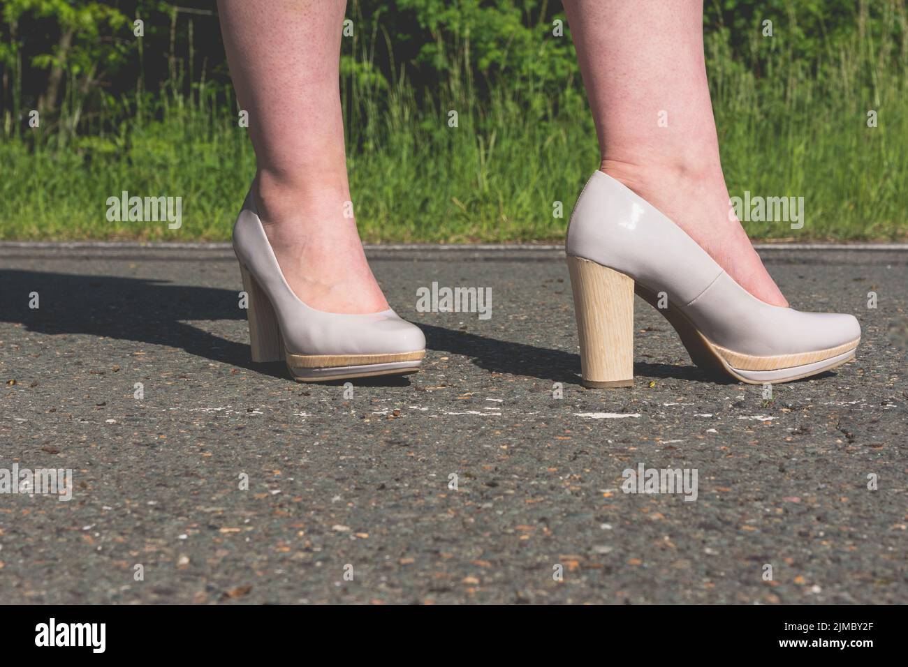 Legs of a woman wearing stylish high heeled shoes Stock Photo