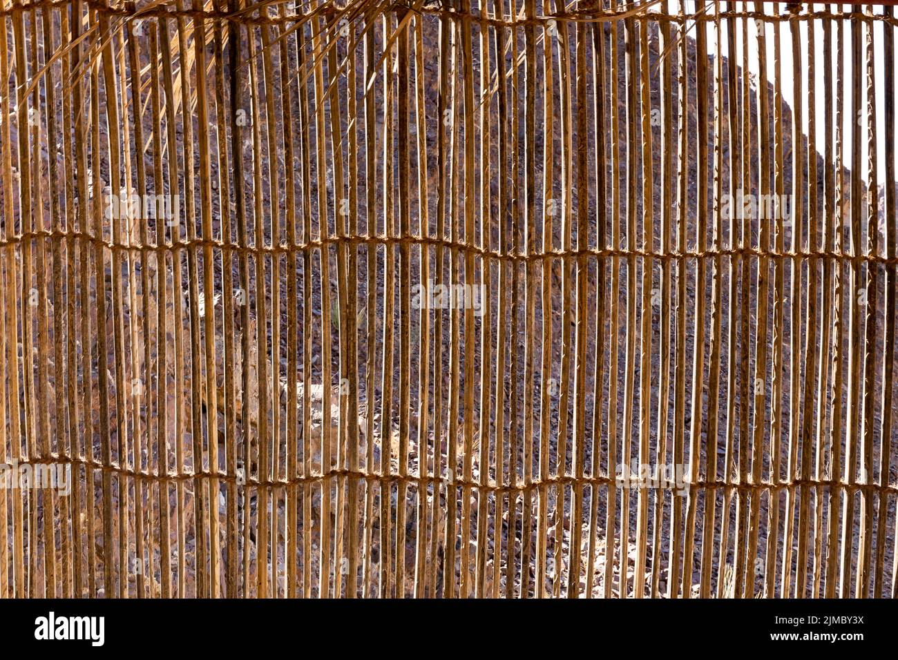 Wall made of cane and palm tree branches, natural mountain shelter in Wadi Shawka, United Arab Emirates. Stock Photo
