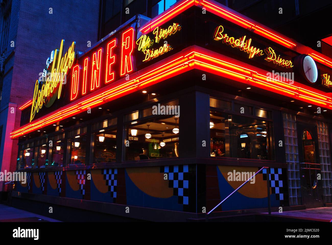 The neon lights of the Brooklyn Diner, in Midtown Manhattan, New York City, is illuminated to draw customers into the restaurant and cafe Stock Photo