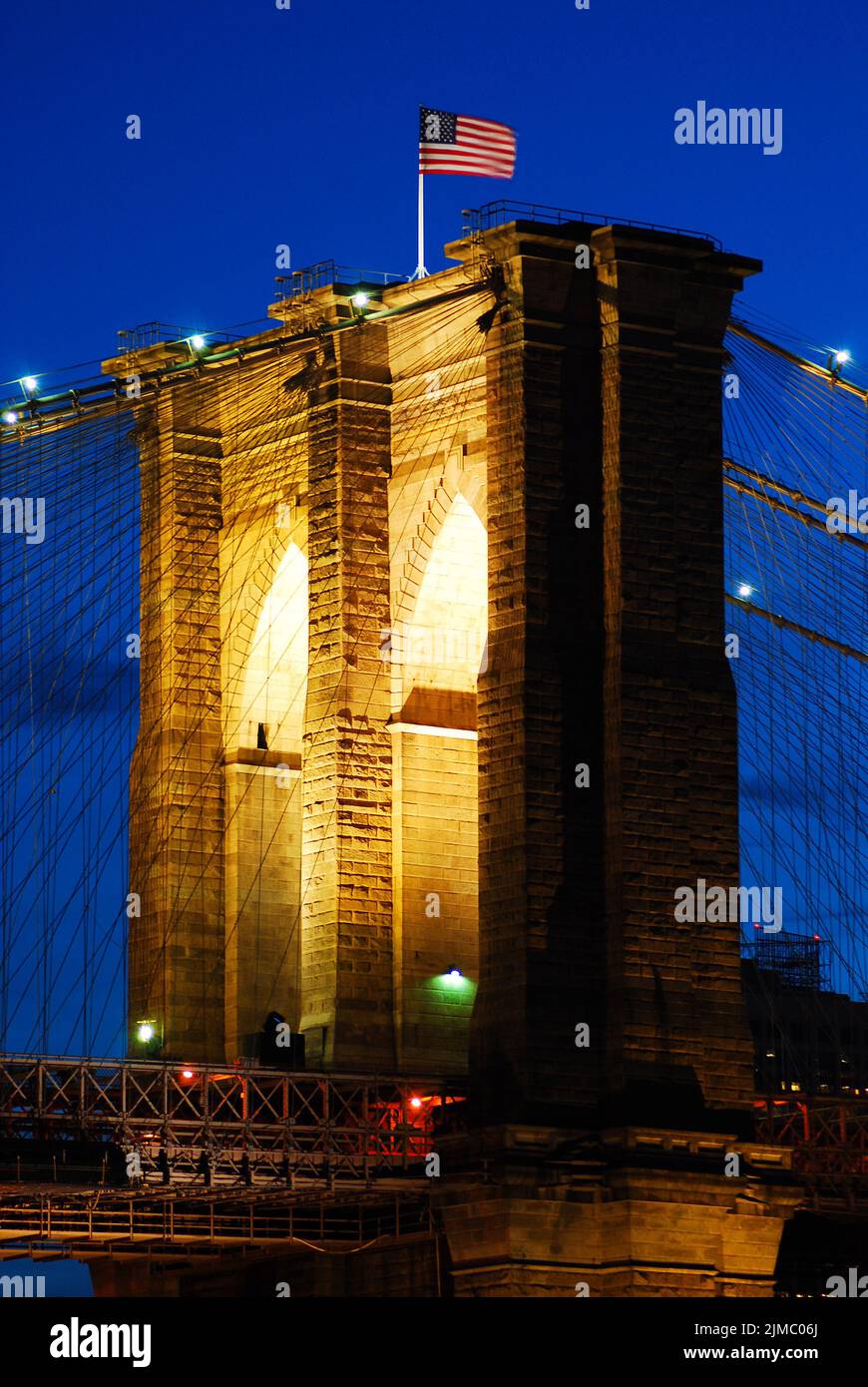 The Brooklyn Bridge is illuminated with special lights during a celebration at dusk in New York City Stock Photo