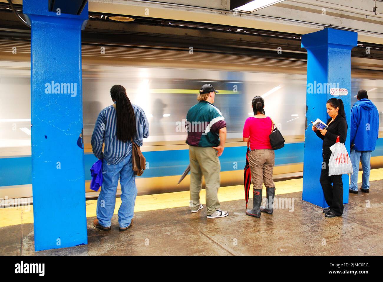 Riders on the Boston subway, or T, wait while their train pulls into their station Stock Photo