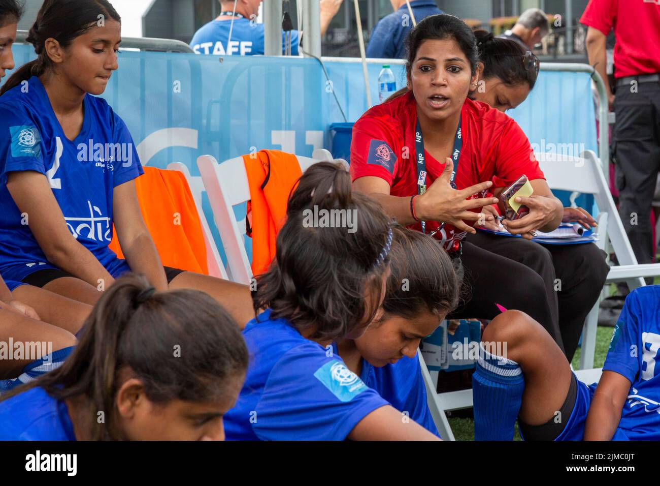 Detroit, Michigan - The women's teams of India and Namibia meet in the Special Olympics Unified Cup football (soccer) tournament. A coach talks to Ind Stock Photo