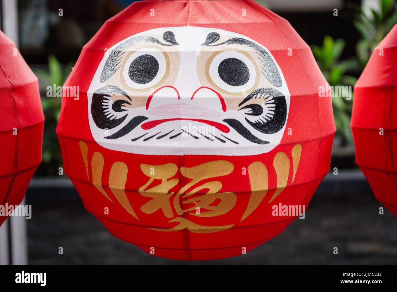 Daruma dolls. The Japanese lucky symbolic dolls hanging in the row with text translation â€œfortuneâ€. Stock Photo