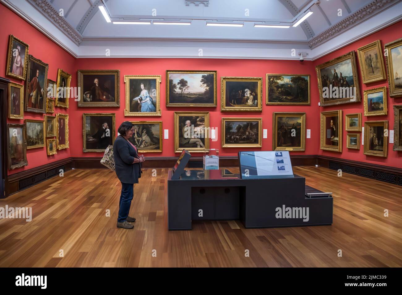 A woman looking at paintings in The McManus: Dundee's Art Gallery and Museum. Stock Photo