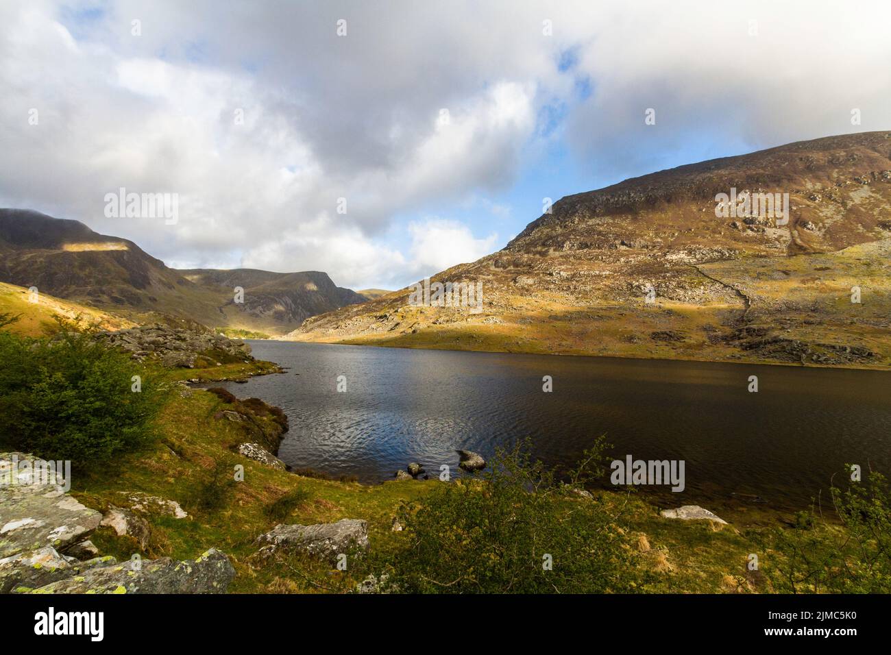 Lake or llyn Ogwen with mountain pen yr ole wen behind. With the Nant Ffrancon Pass, Bethesda, Snowdonia, North Wales, UK, Stock Photo