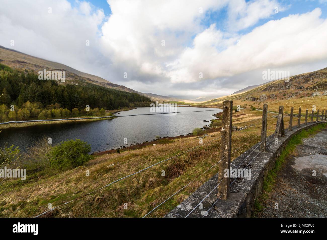 Lake Llyn Llynnau Mymbyr in Snowdonia National Park, old concrete fence in foreground, landscape. Stock Photo