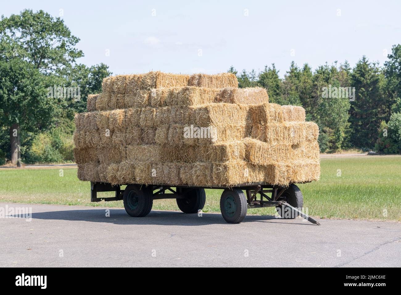 Plain old farm wagon with straw bales stacked Stock Photo