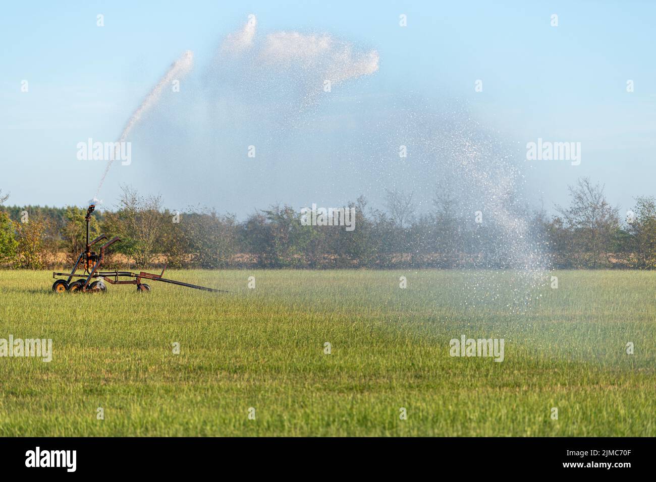 Water Sprinkler in a pasture Stock Photo