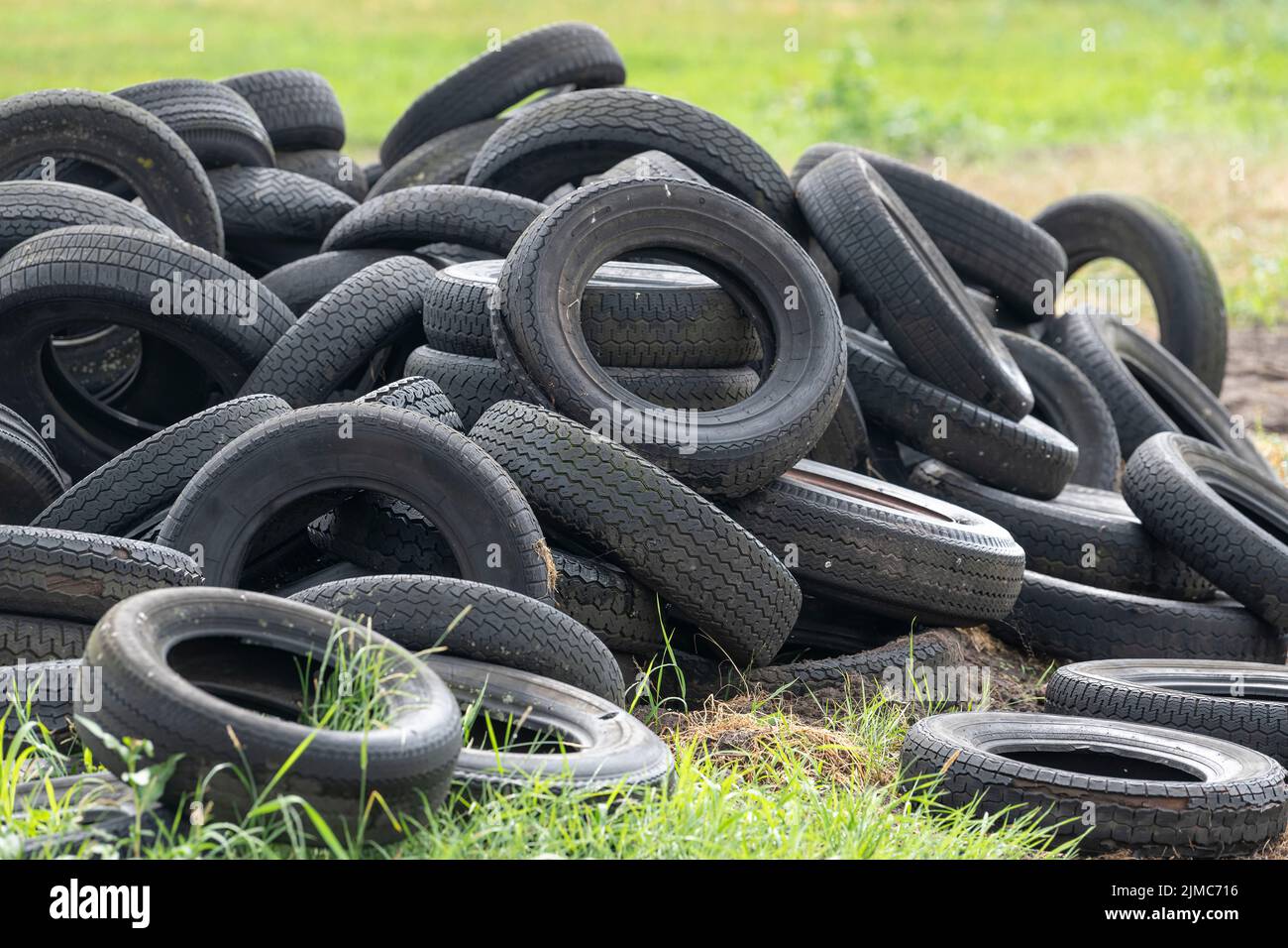 Old tires in a grass field on a farm Stock Photo Alamy