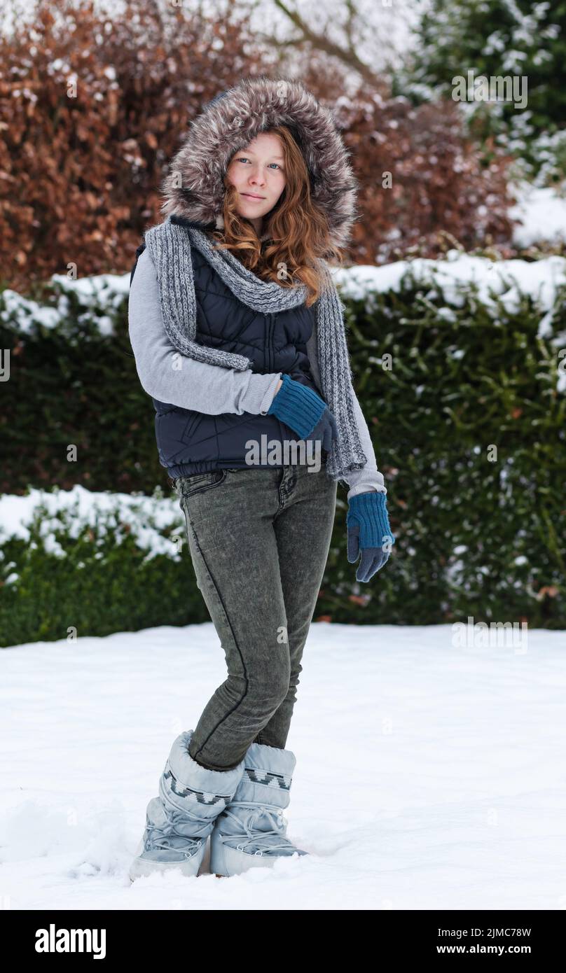 Girl in winter cloths standing in snow Stock Photo