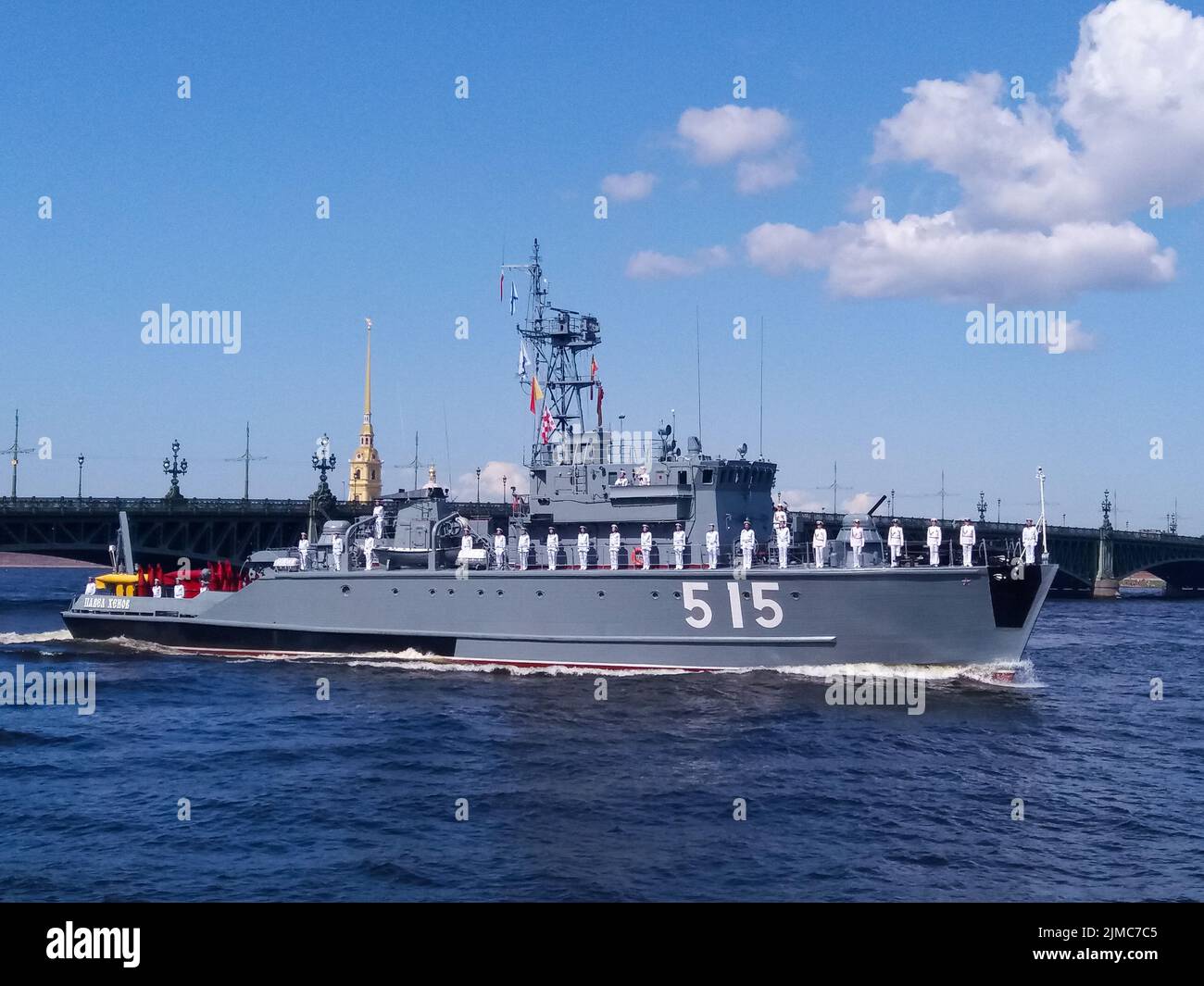 The parade of naval technology. Gray warship with sailors in formal white uniform on board against the background of the bridge Stock Photo