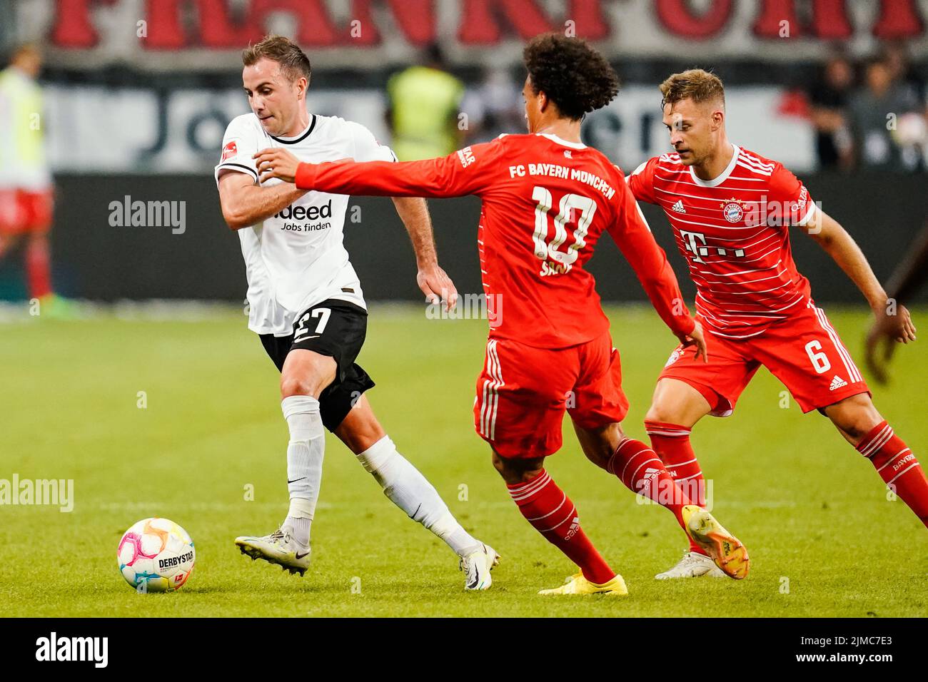 05 August 2022, Hessen, Frankfurt/Main: Soccer: Bundesliga, Eintracht Frankfurt - Bayern Munich, Matchday 1, Deutsche Bank Park. Frankfurt's Mario Götze (l) and Munich's Leroy Sane (m) and Joshua Kimmich fight for the ball. Photo: Uwe Anspach/dpa - IMPORTANT NOTE: In accordance with the requirements of the DFL Deutsche Fußball Liga and the DFB Deutscher Fußball-Bund, it is prohibited to use or have used photographs taken in the stadium and/or of the match in the form of sequence pictures and/or video-like photo series. Stock Photo