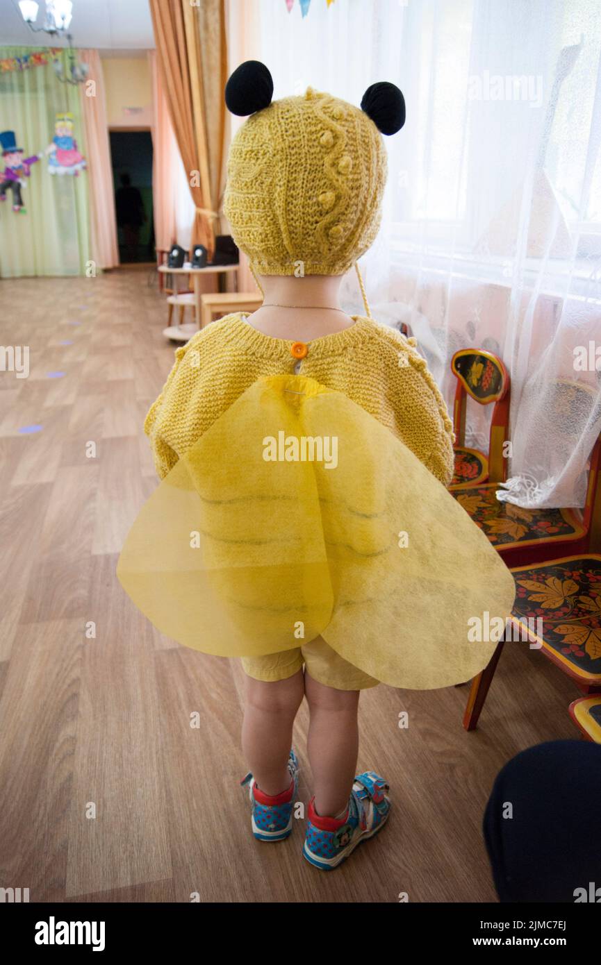 A three-year-old child, a sad blond boy with blue eyes, in a bee costume Stock Photo