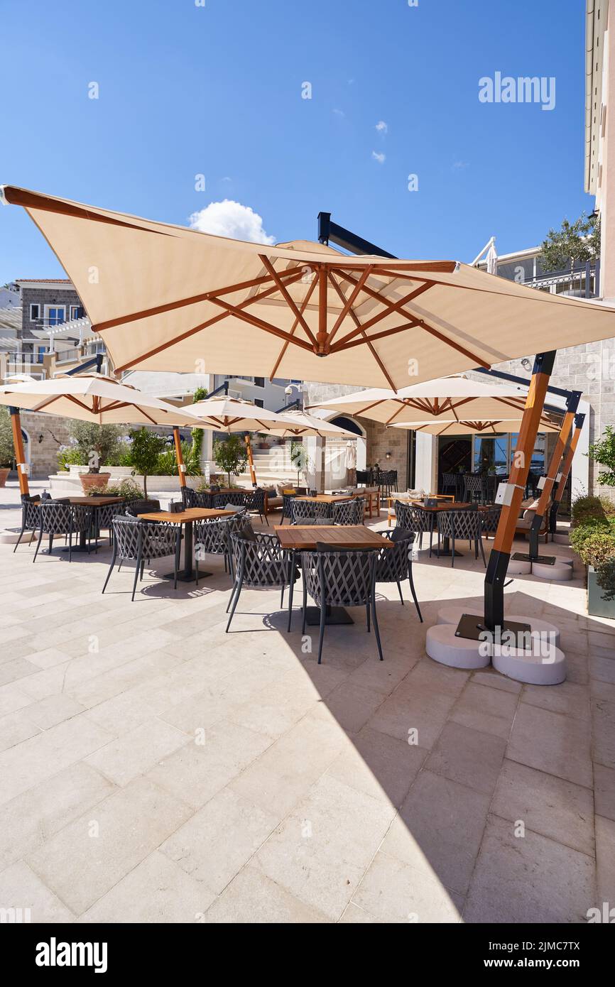 Cozy outdoor restaurant with sun umbrellas without people in Montenegro Stock Photo