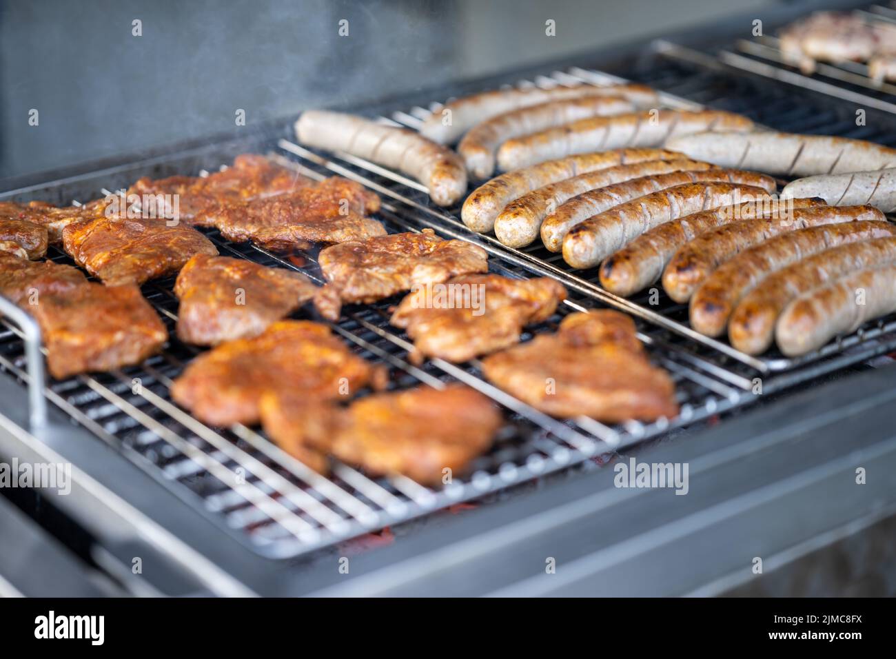 Food, Deutschland, Rheinland-Pfalz, July 30. Schweine Fleisch und Bratwürste liegen auf einem Holzkohlegrill. Stock Photo