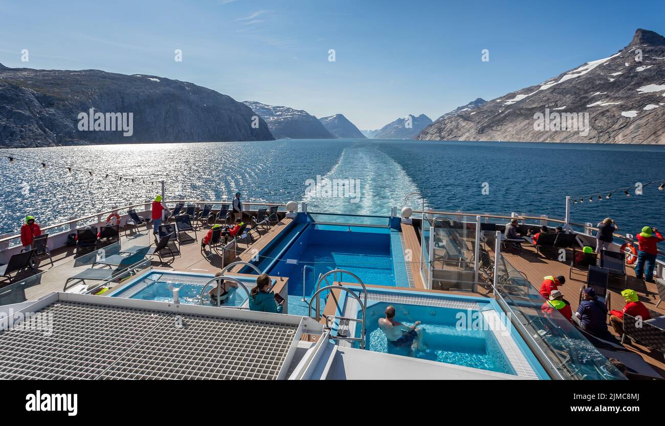 Passengers enjoying the hot tubs and arctic scenery on Hurtigrutens MS Fridtjof Nansen in Prince Christian Sound, South Greenland on 22 July 2022 Stock Photo
