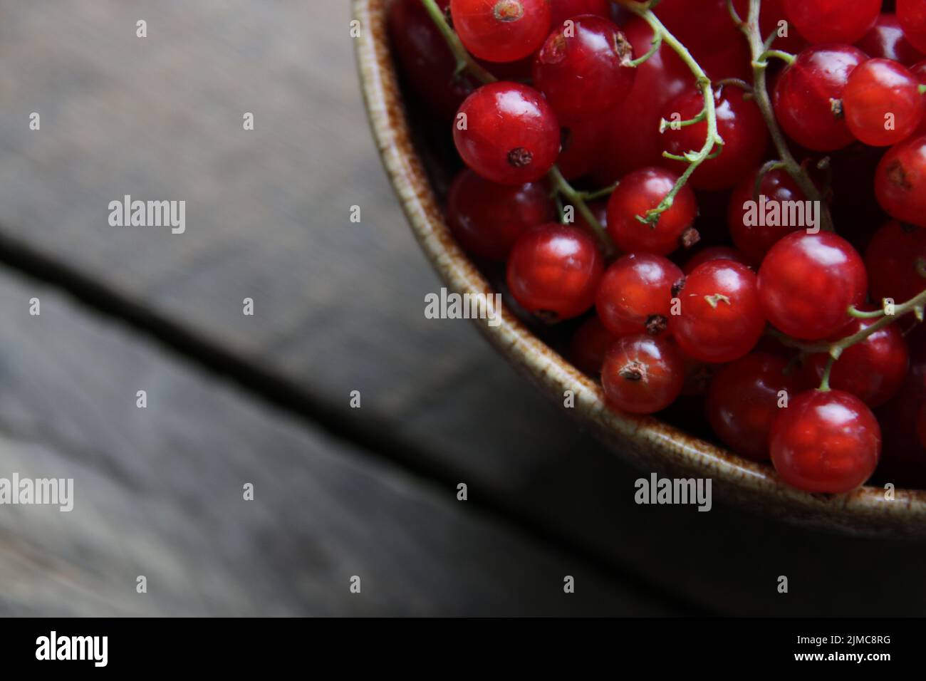 Ripe red currant in a cup on vintage background Stock Photo