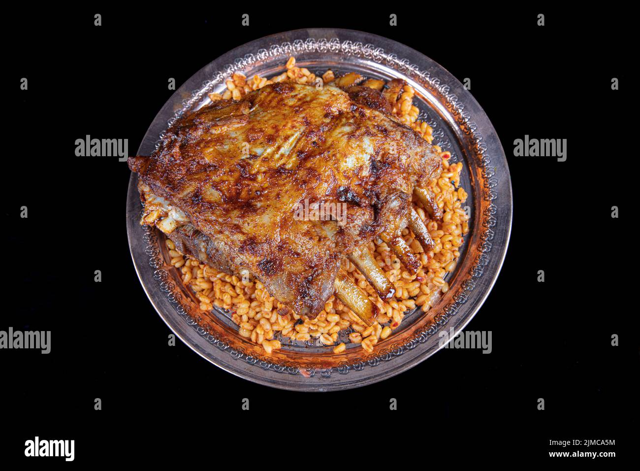 Lamb ribs on bulgur pilaf. Stuffed Ribs isolated on black background