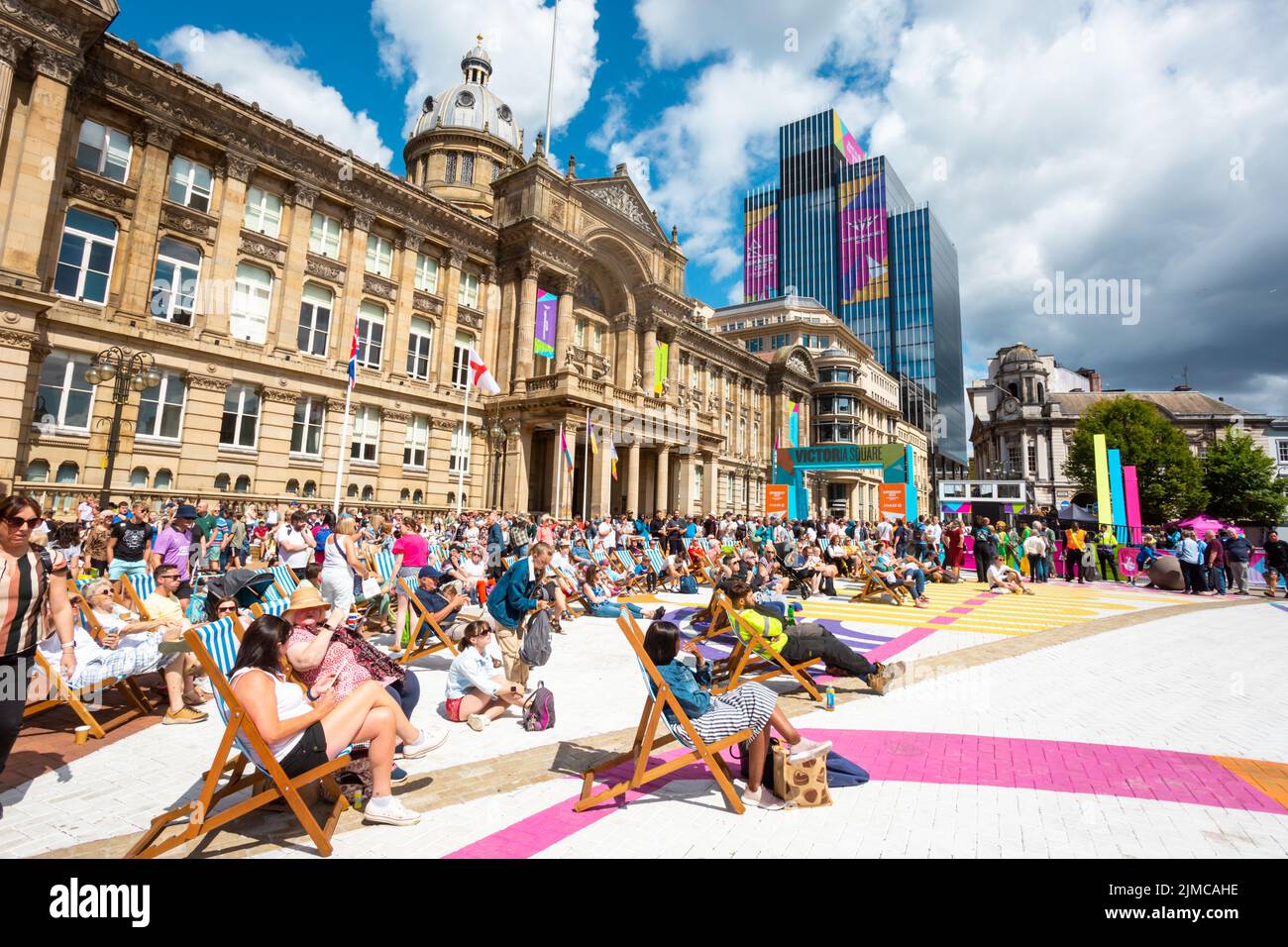 Crowd of spectators enjoying the summer sunshine in Victoria Square Birmingham watching a big screen Commonwealth Games 2022 Stock Photo