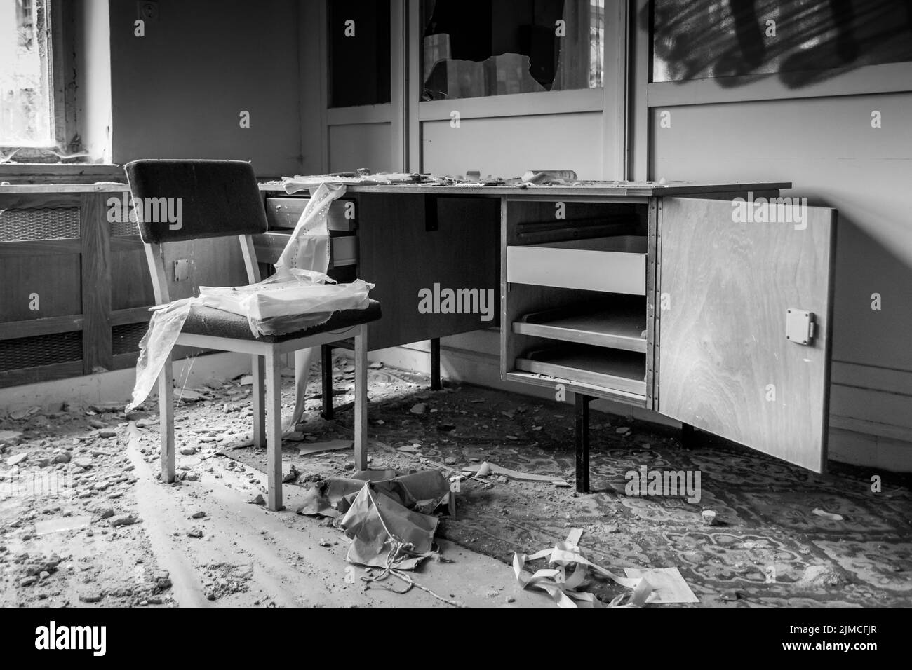 An old dilapidated room with desk and chair Stock Photo