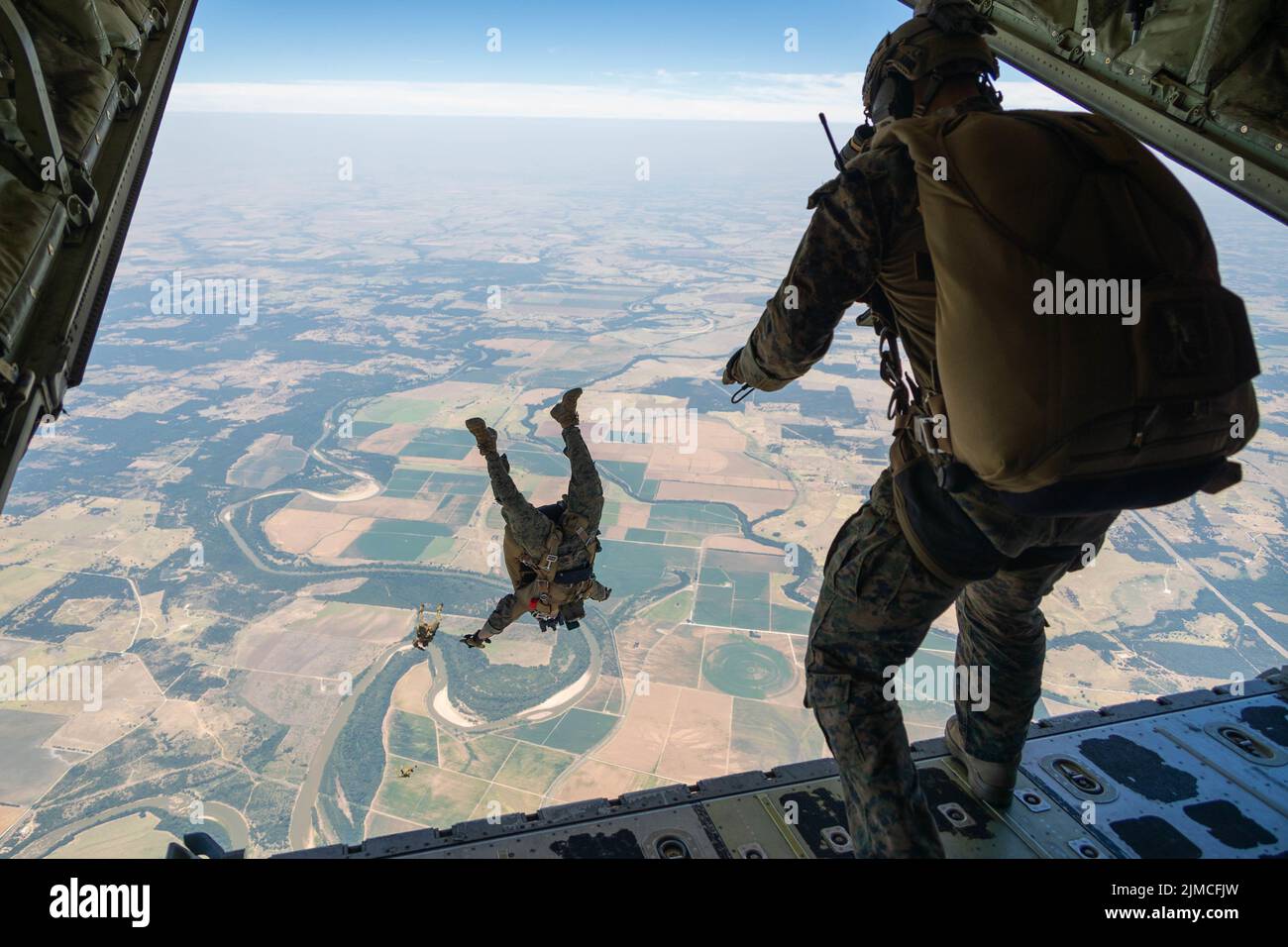 U.S. Marines with Force Reconnaissance Company, III Marine Expeditionary Force, jump from a C-130 Hercules at Hearne Municipal Airport, Hearne, Texas, July 20, 2022. This training was conducted during exercise Desert Eagle 2022 to reinforce proper techniques and the Marines’ proficiency in support of future III MEF operations within the Indo-Pacific region. (U.S. Marine Corps photo by Cpl. Zachary Sarvey) Stock Photo