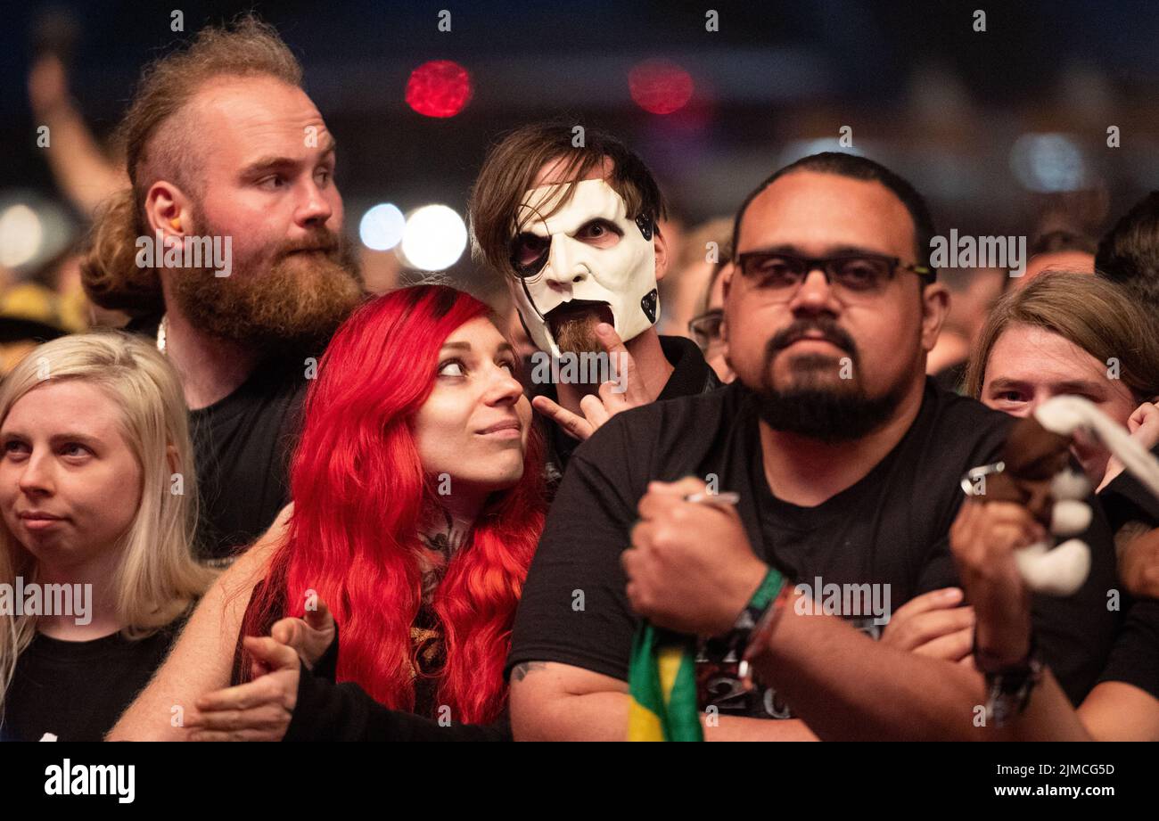 Wacken, Germany. 05th Aug, 2022. A festival-goer wears a mask of the band Slipknot at the Wacken Open Air Festival. The WOA is considered the largest heavy metal festival in the world. Credit: Daniel Reinhardt/dpa/Alamy Live News Stock Photo