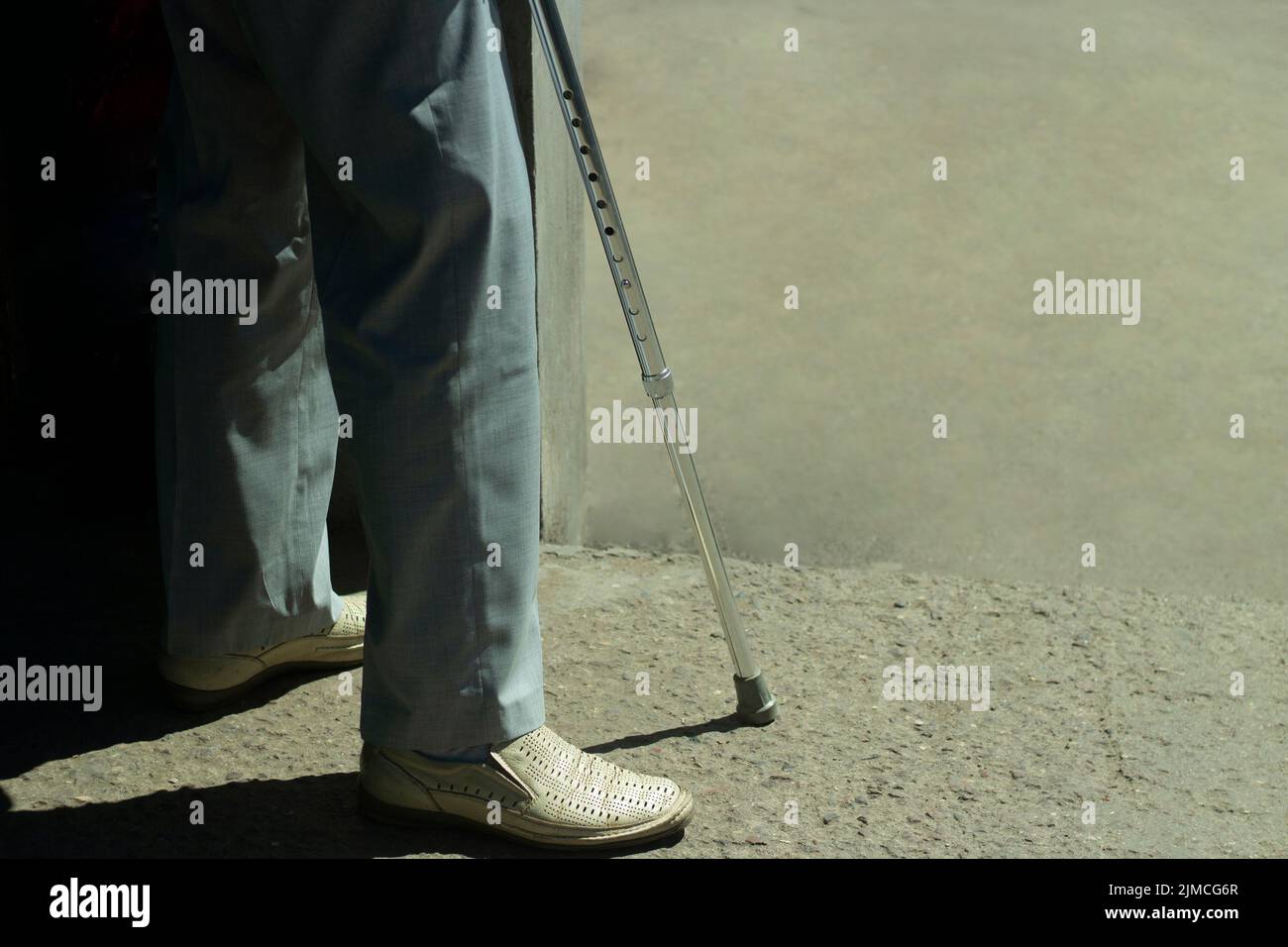 Walking stick. A man with a leg injury. Disabled with a device for