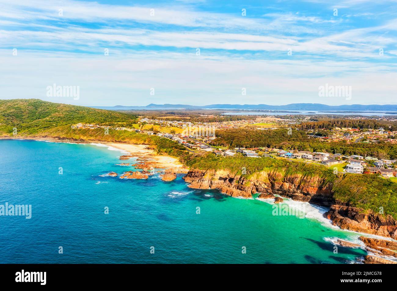 Rocks and cliffs on Pacific coast around burgess beach in Forster town of australia - aerial landscape view from open sea. Stock Photo