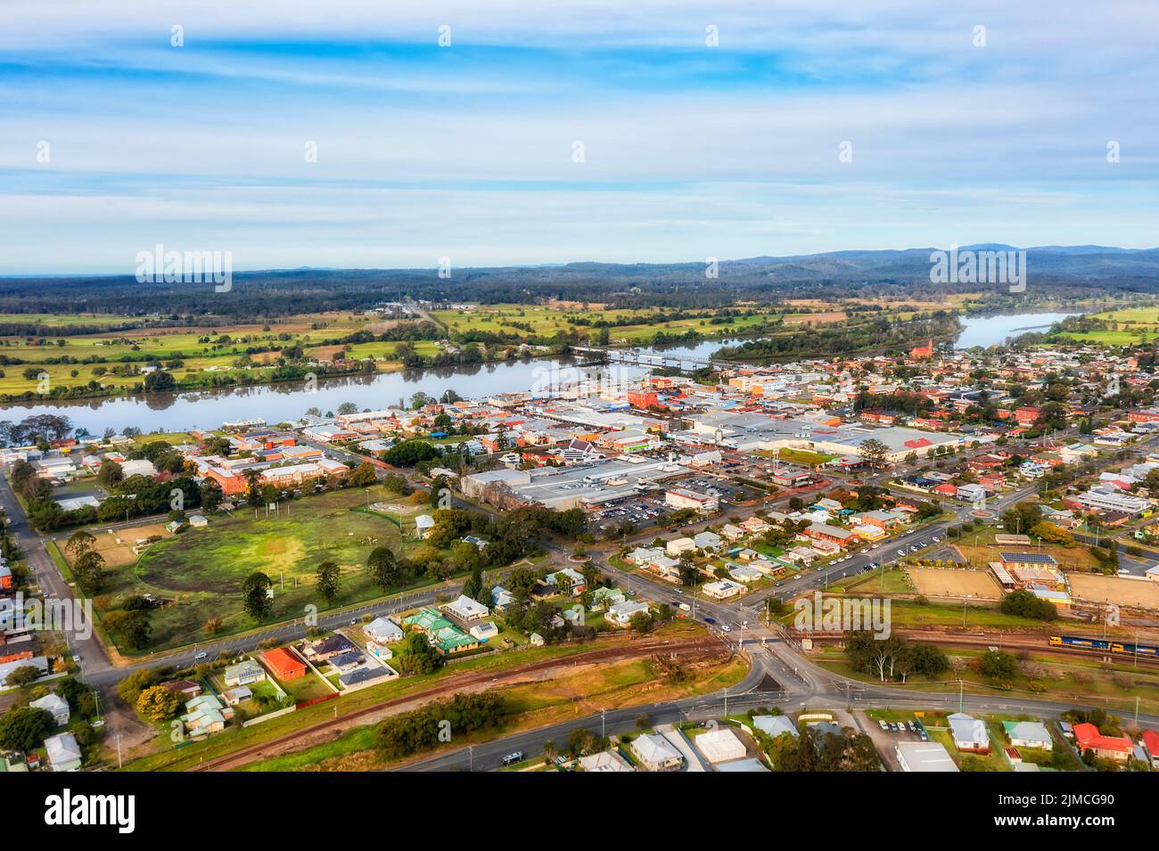 Taree town downtown shopping district and residential suburbs around on shores of Manning river Marting bridge - aerial townscape. Stock Photo
