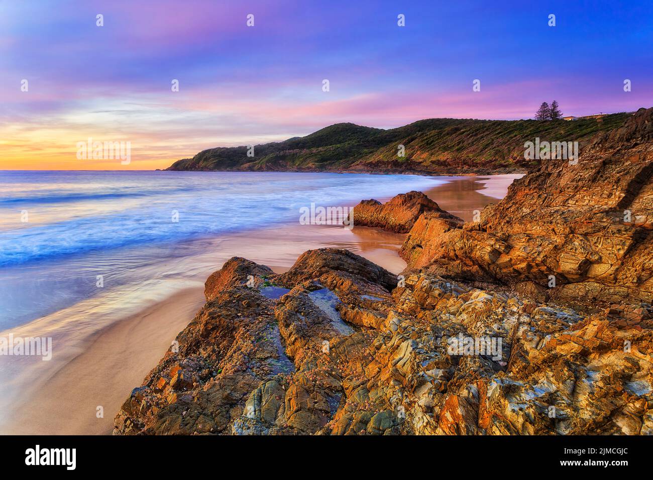 Hawke cape and headland from burgess beach in Forster town on Pacific coast of Australia at scenic seascape sunrise. Stock Photo
