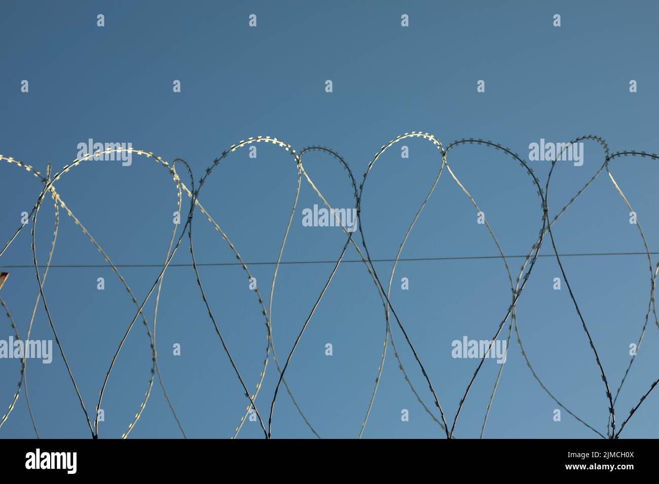 Barbed wire on fence. Fencing of industrial zone. Safety from thieves