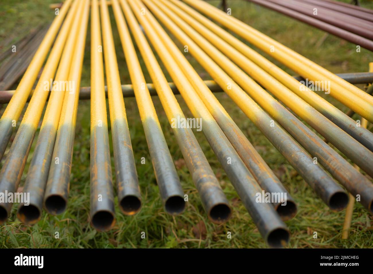 Pipes lie in row. Steel parts. Yellow pipes for gasification. Urban