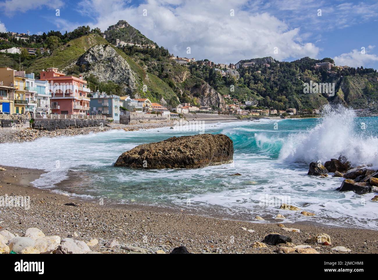 Sea surf in front of the promenade with Taormina on the hill, Giardini-Naxos, east coast, Sicily, Italy Stock Photo
