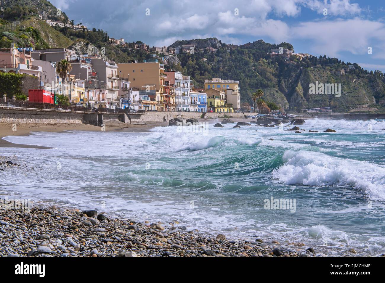 Sea surf in front of the promenade with Taormina on the hill, Giardini-Naxos, east coast, Sicily, Italy Stock Photo