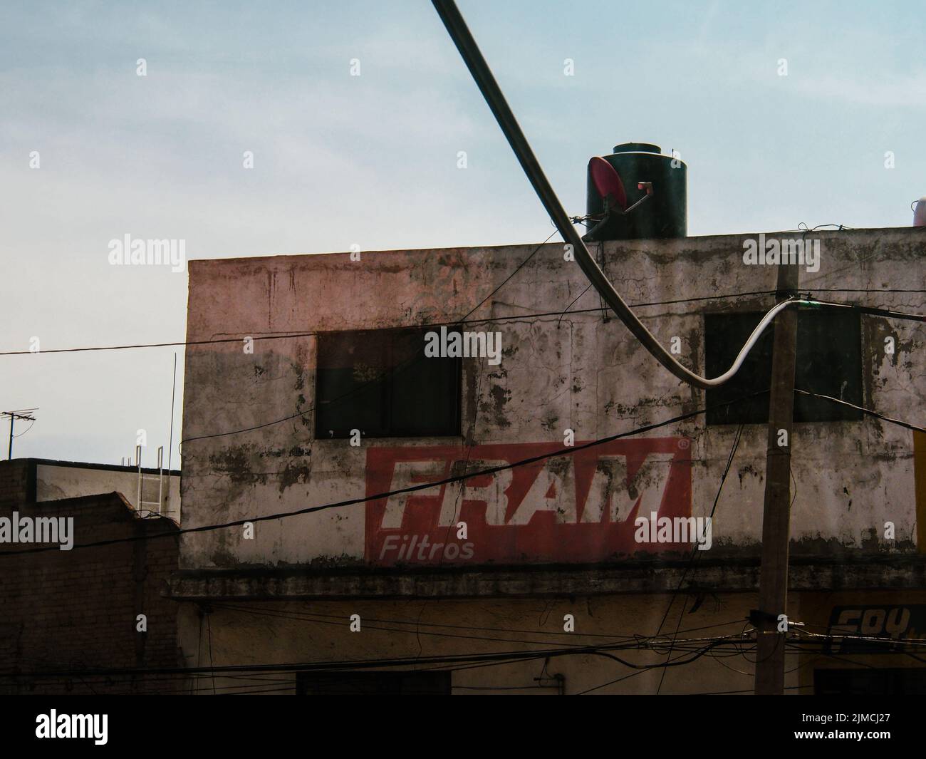 An old run down building with a industrial sign and utilitiy wire Stock Photo