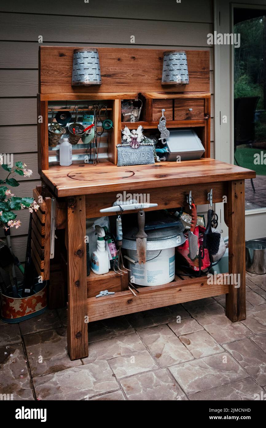 Home gardener cedar potting bench or table with lights on a patio. Stock Photo