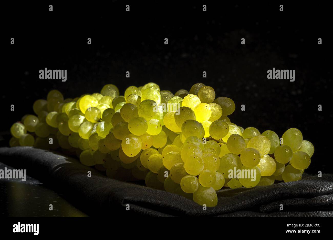 Closeup of heap of fresh ripe grapes placed on black tablecloth Stock Photo