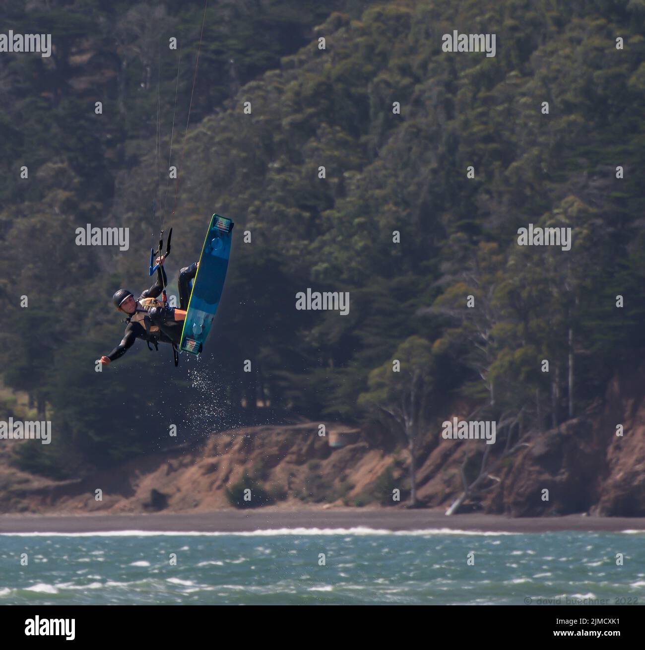 Kitesurfer lifted into the air above whitecaps against the backdrop of the Marin Headlands in San Francisco Stock Photo