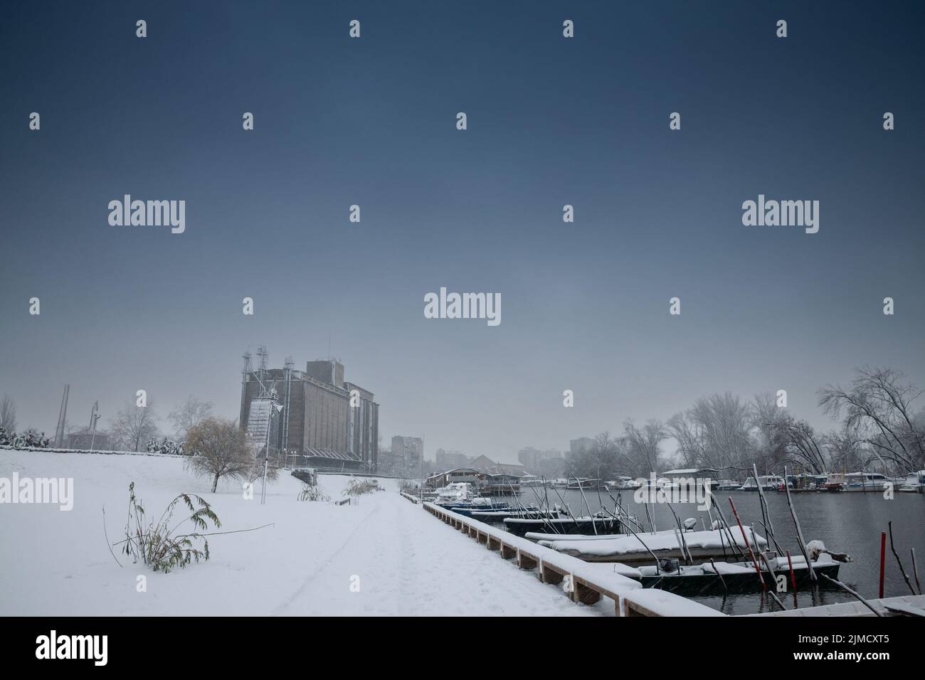 Picture of the city center of Pancevo with its iconic silos and the Tamis river during a snowstorm. Pancevo is a city and the administrative center of Stock Photo