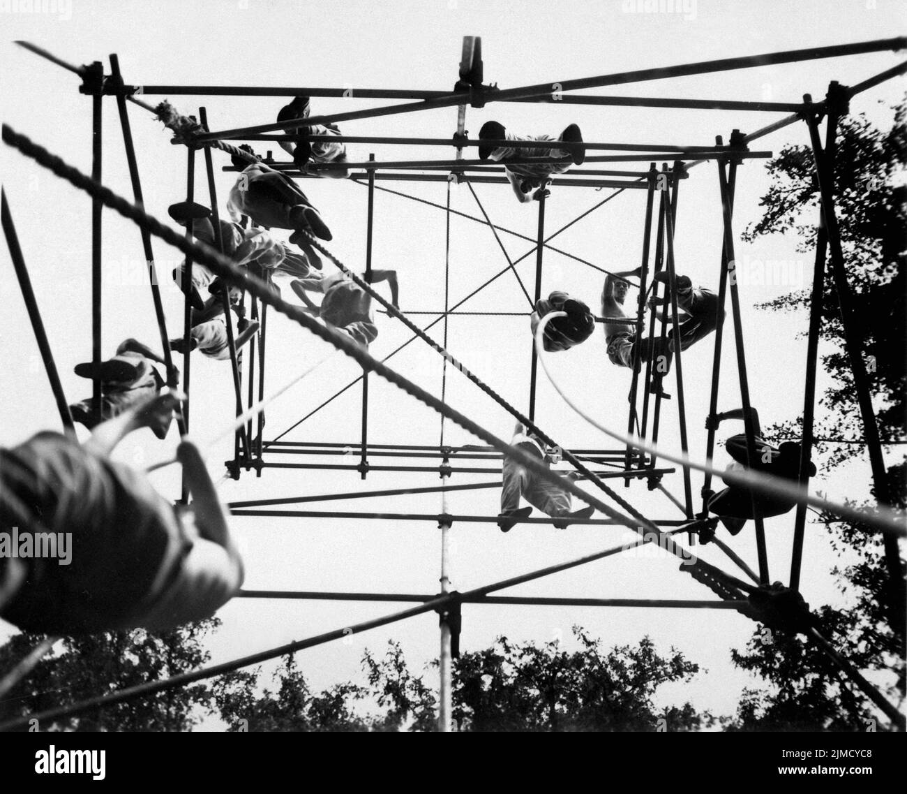 Special forces, led by the SOE (Special Operations Executive) were trained as special agents to be parachuted into France to help co=odinate the Allied war effort with the French resistance. The opearation was called Operation Jedburgh and the soldiers were known as Jedburghs, or Jeds. Here they are seen training on high bars on an obstacle course at Milton Hall Stock Photo