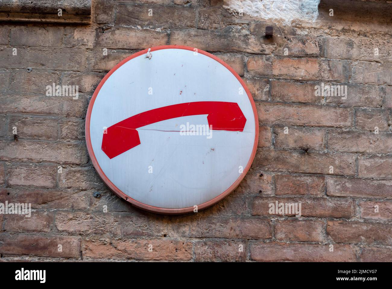 Red telephone receiver, sign on house wall, Siena, Tuscany, Italy Stock Photo