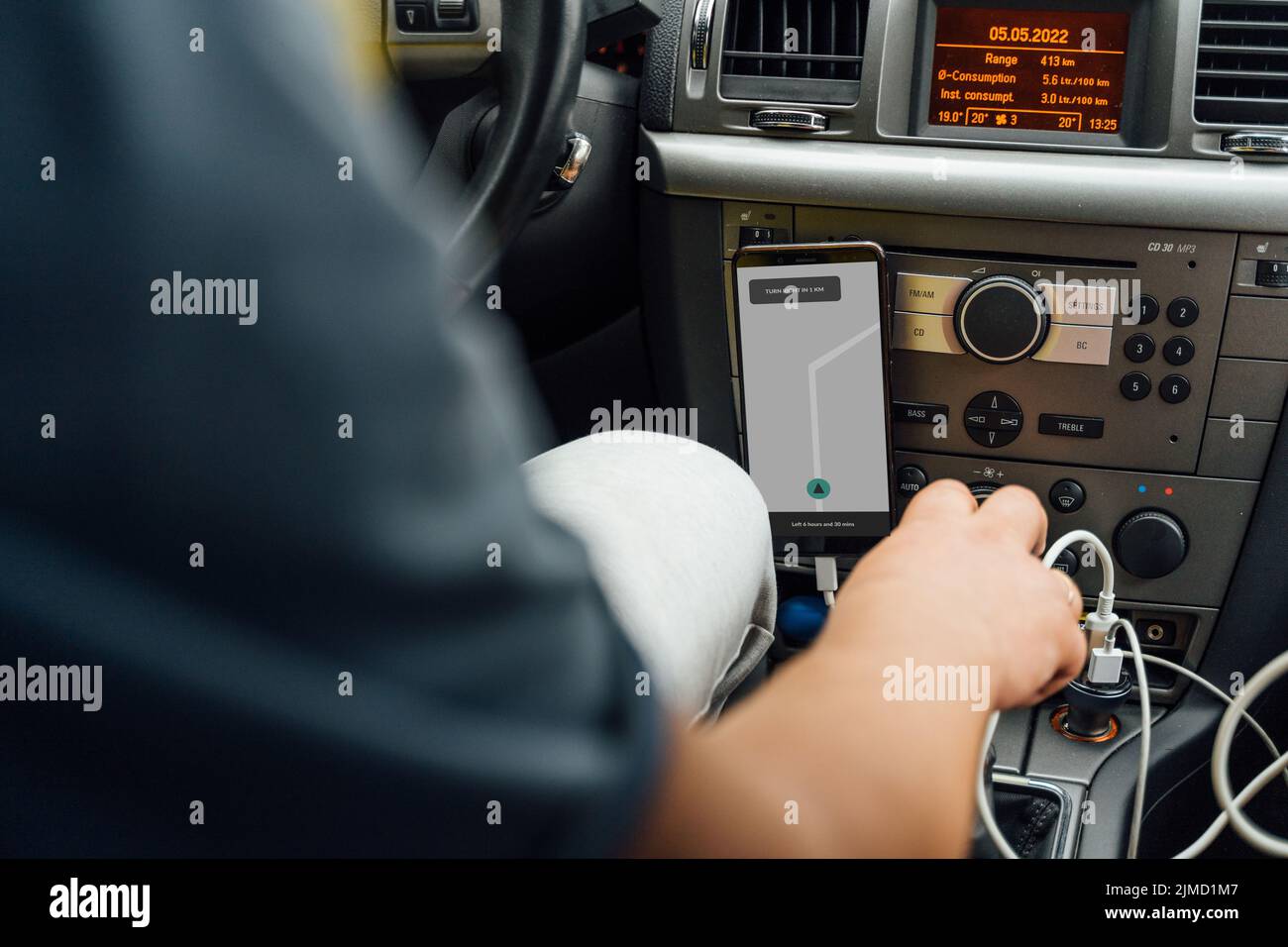 Cropped unrecognizable male with navigator on mobile phone driving modern car on road Stock Photo
