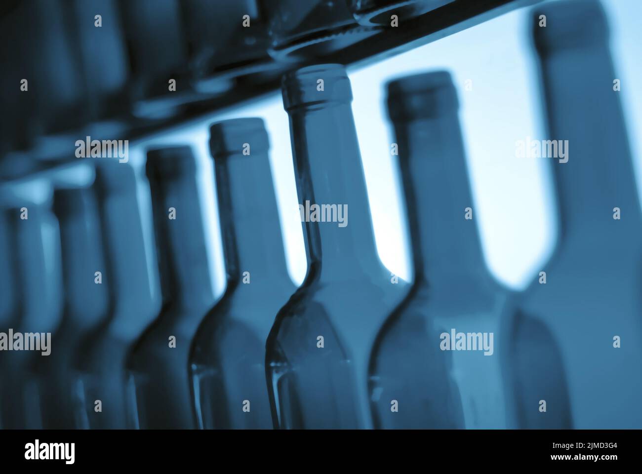 Empty wine bottle necks in a row as illustration of binge or problem drinking and depression caused Stock Photo