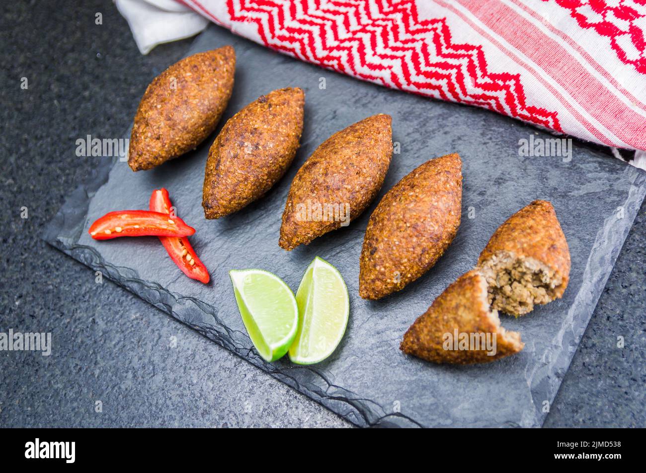 Delicious Lebanese food, kibbeh (kibe) with sauces and lemon on black