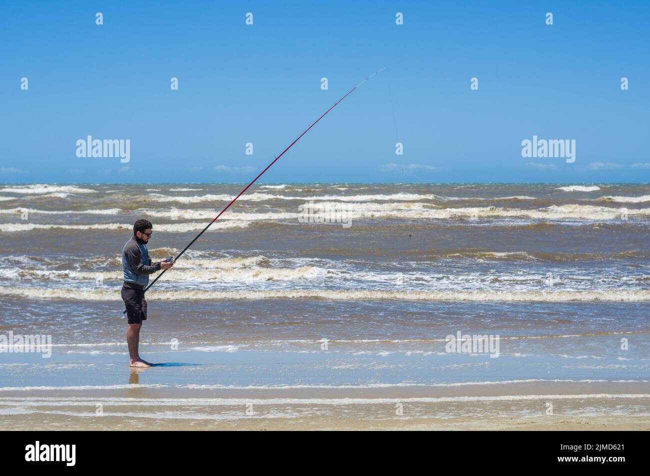 Young man fishing on beach, sport fishing Stock Photo Alamy